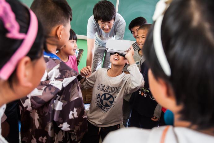 5.北京科技报的记者正在给同学们演示VR眼镜，这是报社特地为孩子们带去的，同学们第一次体验这样的科技酷品，个个兴奋不已。20180515-_MG_93950