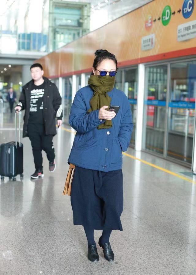 周迅机场又穿裙子了，半身裙搭配打底裤，随性保暖还时髦！